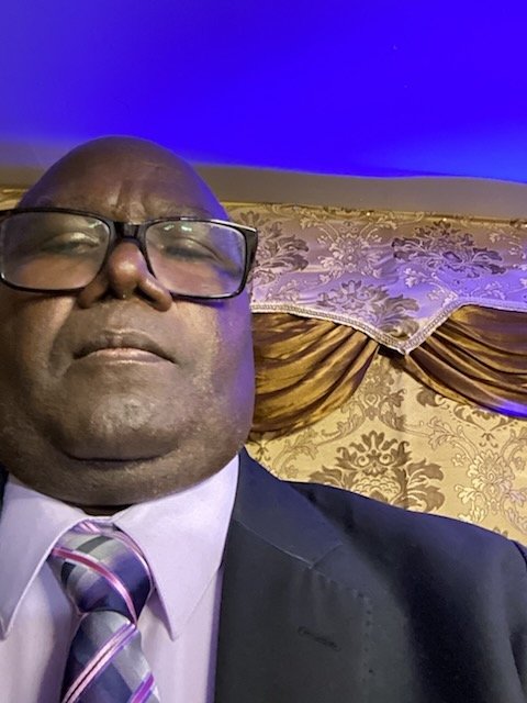 Dr. Jonias Destiné in a dark suit and striped tie